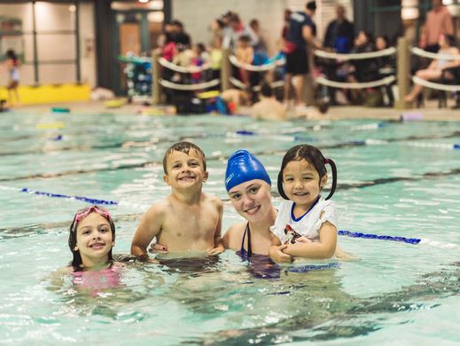 Three young kids with their swim instructor at City Centre Aquatic Complex.