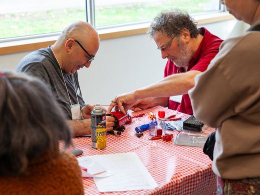 Volunteers repairing a mechanical item for resident at Coquitlam Repair Cafe