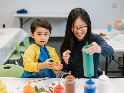 Parent and child making a fall-themed art activity
