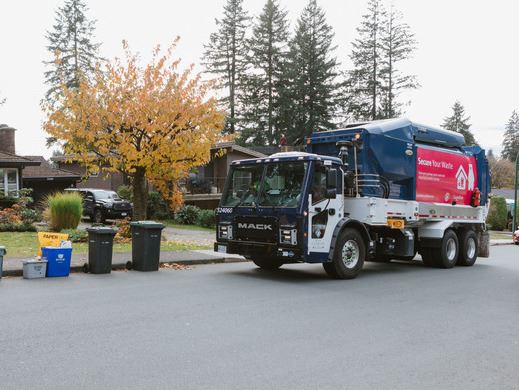 Waste Collection Truck on street ready to collect garbage and green cart waste from carts.