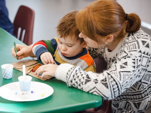 child and mother drawing at a table