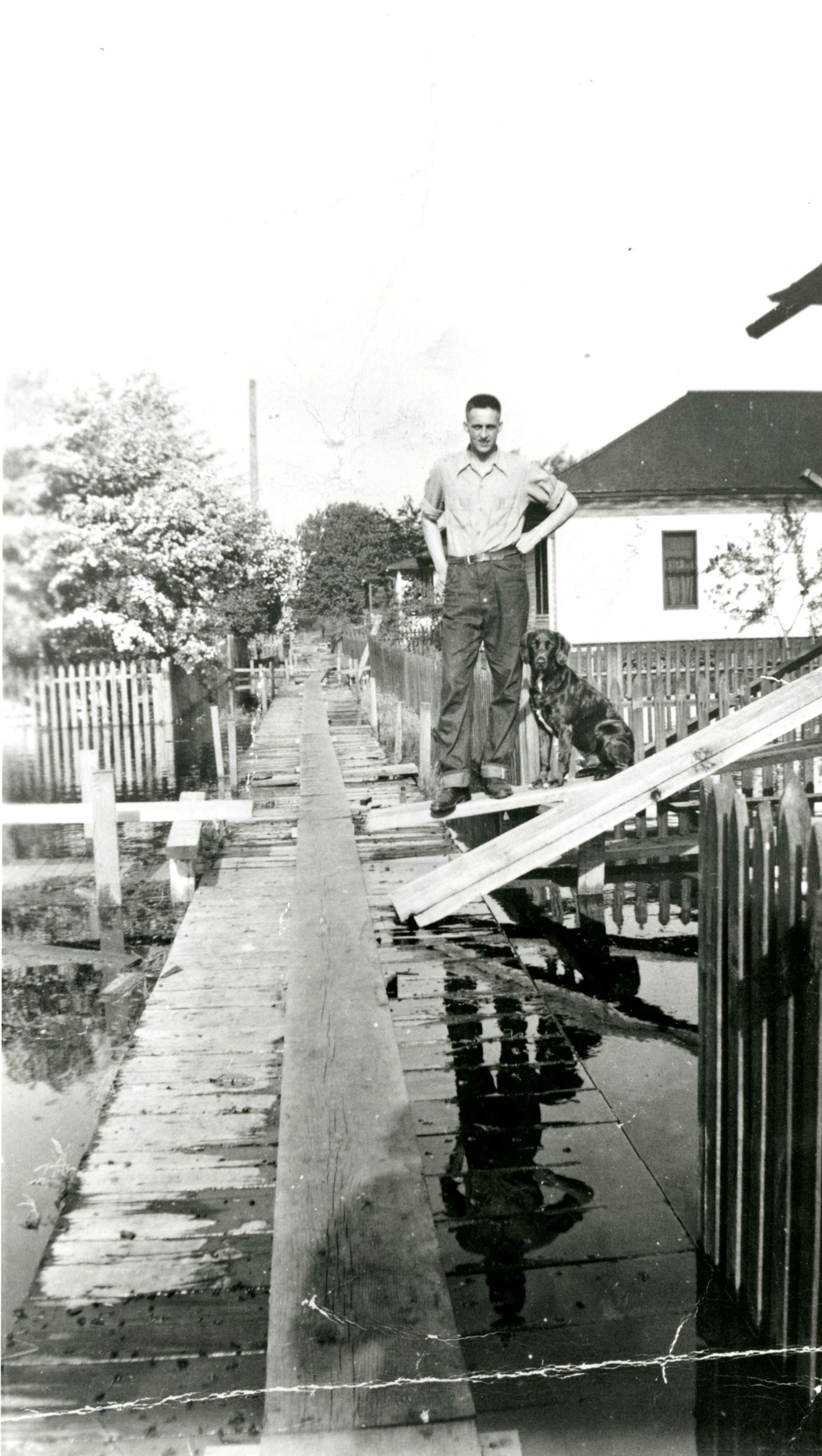 Hank Locken stands on a floating wooden sidewalk at Fraser Mills, 1948 (Source City of Coquitlam Arc Opens in new window