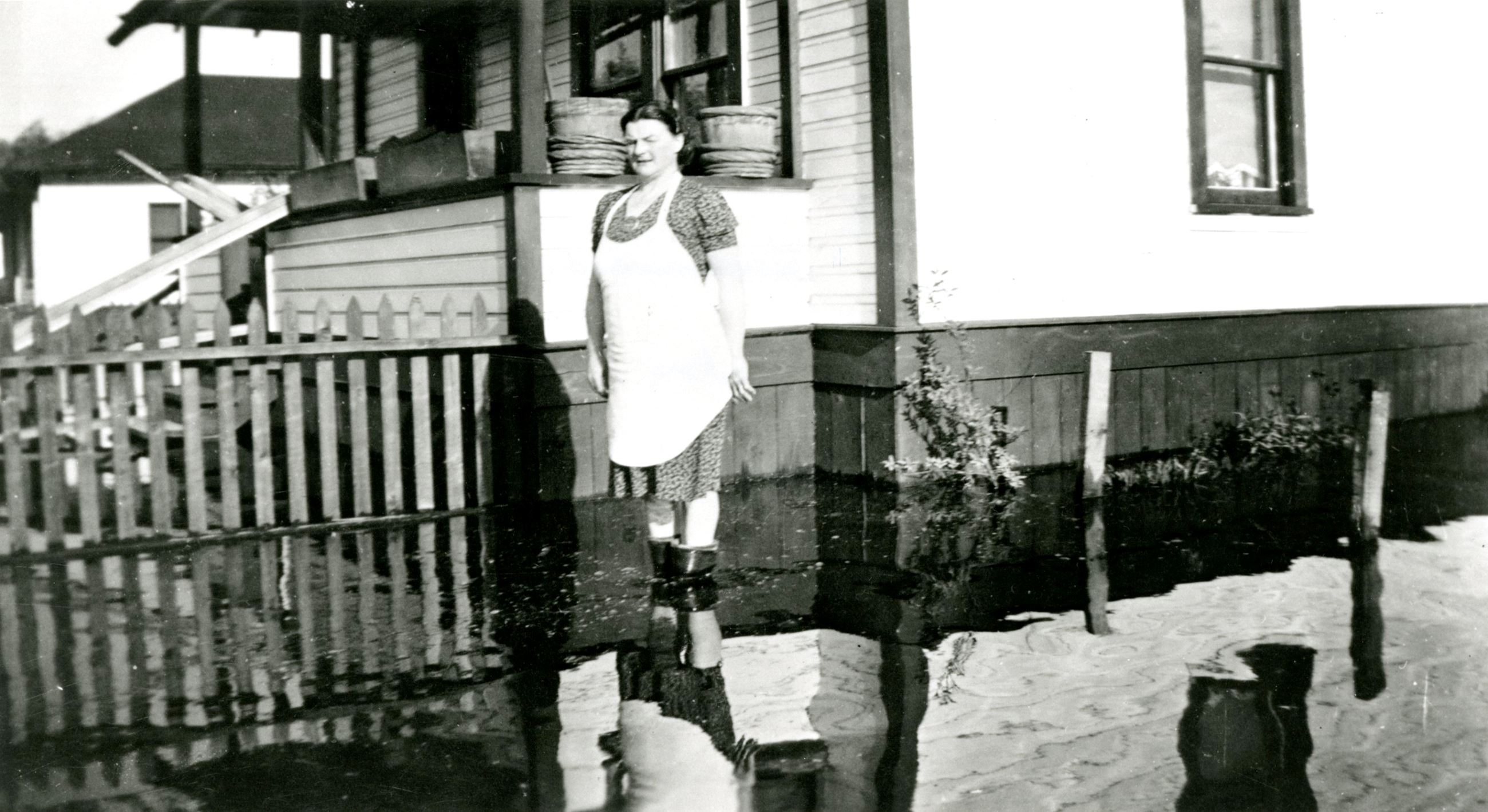 Mrs. Borghild Locken outside her home during the 1948 flood (Source City of Coquitlam Archives, C6.1 Opens in new window